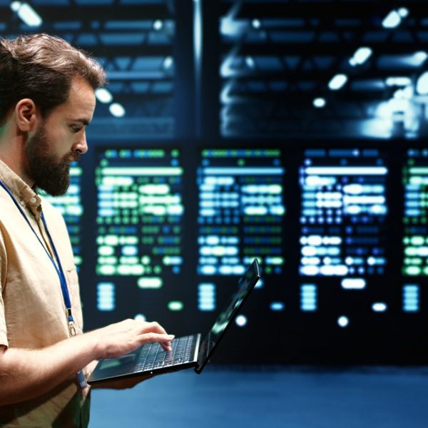 Developer checking event logs and diagnostic tools to identify server issues root cause. Programmer using laptop to check supercomputer operating system configuration settings